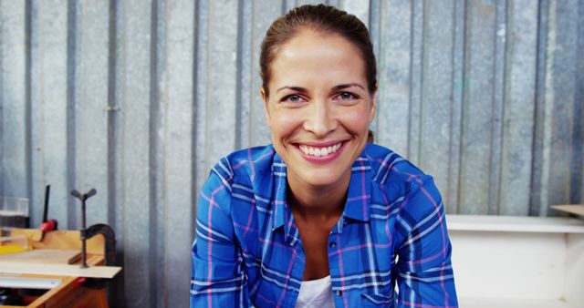 Smiling Woman in Plaid Shirt Working in Workshop - Download Free Stock Images Pikwizard.com