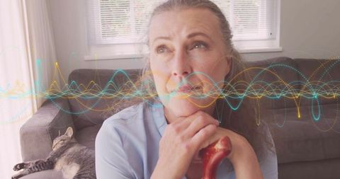 Senior Woman Contemplating Life with Cat Companion in Cozy Living Room