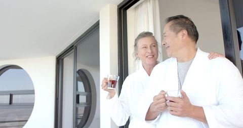 Senior Couple Relaxing with Tea on Bright Balcony