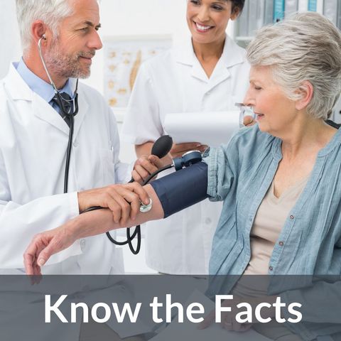 Doctor measuring blood pressure of mature female patient