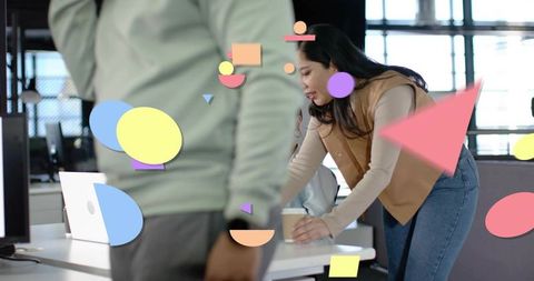 Leaning woman reaching for coffee in modern open-plan office with colorful shape overlays