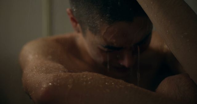 Emotional man sitting in shower with water streaming down - Download Free Stock Images Pikwizard.com