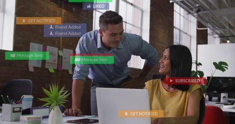 Collaborating coworkers at laptop in modern open office with social notifications overlay