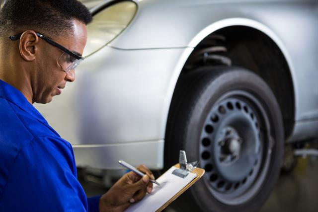 Mechanic Preparing Checklist at Auto Repair Garage - Download Free Stock Photos Pikwizard.com