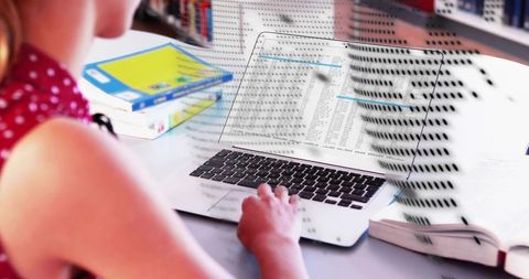 Teenager studying on laptop with patterned data shadow and open textbook at desk