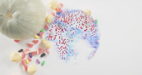 Holographic globe with red pins hovering on white surface, melon and assorted candies