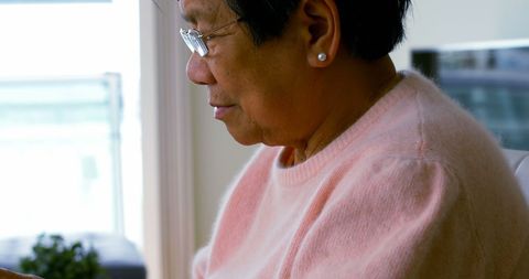 Elderly Woman Engaging with Tablet in Cozy Home Environment