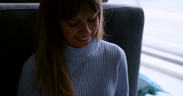 Smiling Woman with Long Hair Wearing Blue Sweater in Relaxed Setting - Download Free Stock Images Pikwizard.com