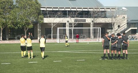 Youth soccer team celebrating goal school field