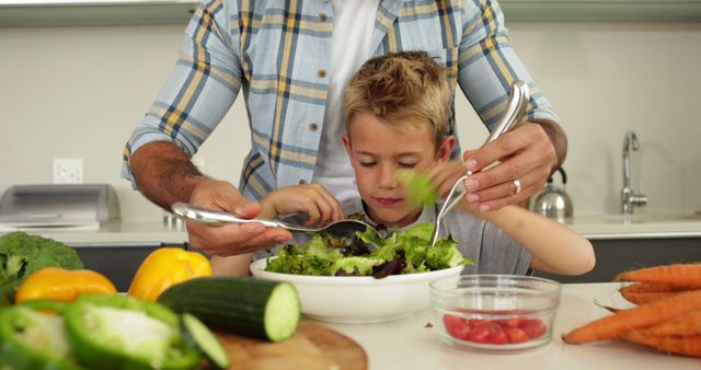 Father and son making fresh salad together in kitchen - Download Free Stock Images Pikwizard.com