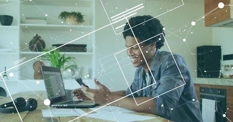 Casual Home Office Setup with Man Using Laptop and Smartphone