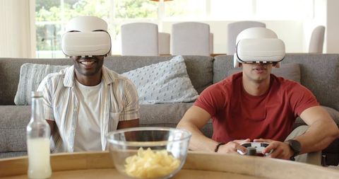 Diverse Friends Playing VR Games on Sofa with White Headsets in Bright Living Room