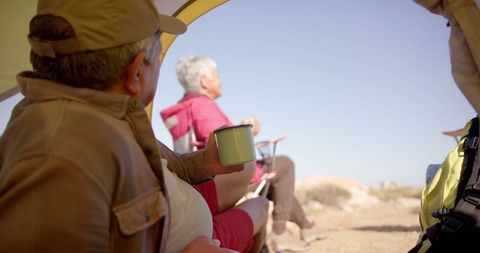 Senior Couple Relaxing Outside Camping Tent