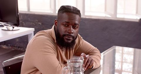 Businessman Reflecting at Glass Table in Modern Office