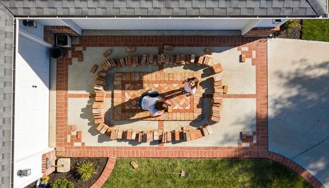 Parent and child arranging bricks on front-entry patio, aerial view of decorative brick inlay