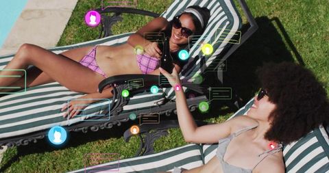 Two women sunbathing on striped loungers passing drink with social media icons overlay