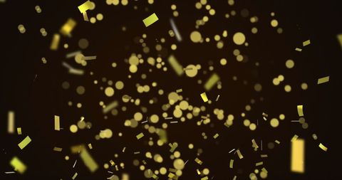 Golden confetti falling on black background