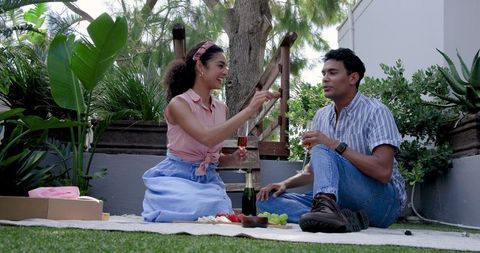 Couple Enjoying Outdoor Picnic with Snacks and Laughter