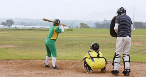 Softball players anticipating pitch on field ready for game action