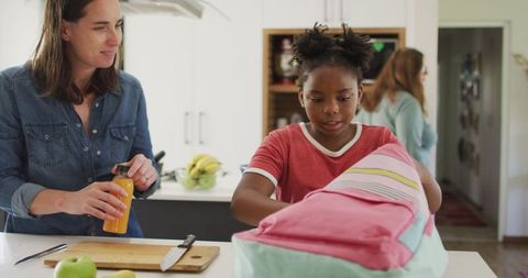 Mother and Daughter Packing Lunch in Modern Kitchen