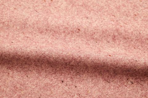 Soft pink heathered fabric texture showing woven linen effect with subtle flecks