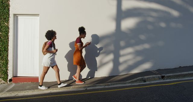 Two Young Women Walking on Sunny Street - Download Free Stock Images Pikwizard.com