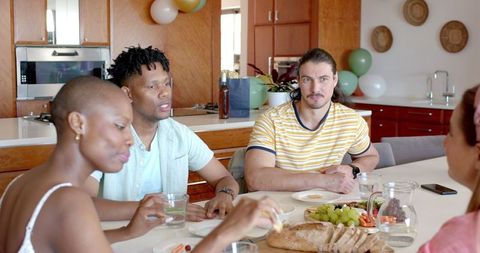 Friends Enjoying Casual Conversation at Home Around Dining Table
