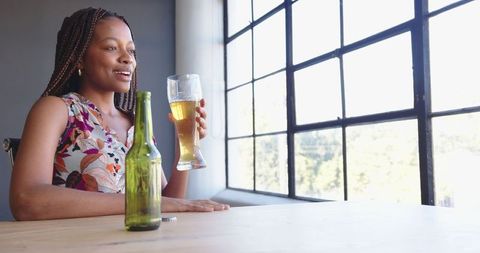 Young Latina Woman Enjoying Refreshing Beverage in Sunlit Room