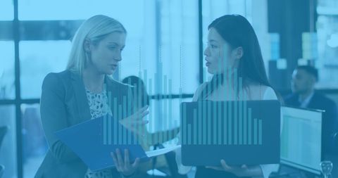 Businesswomen Analyzing Financial Data with Laptop and Documents