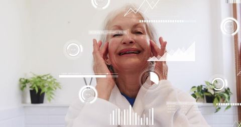 Smiling senior woman touching face in bathrobe with augmented reality health hud overlays