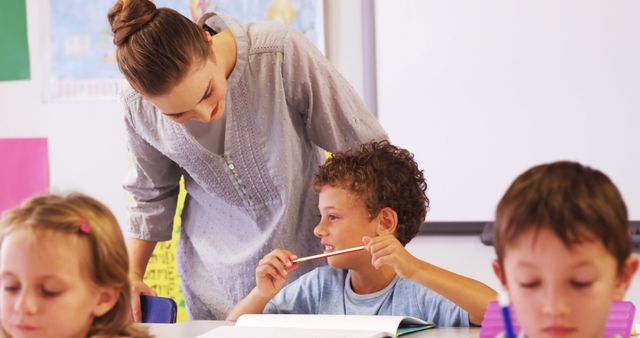 Teacher Assisting Young Students in Classroom Discussion - Download Free Stock Images Pikwizard.com