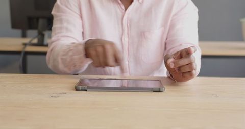 Businessman Interacting with Tablet Device on Modern Office Desk