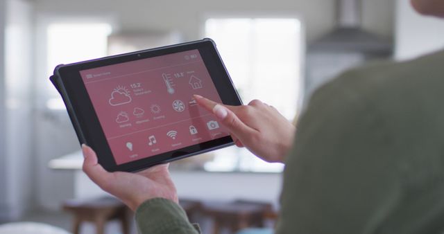 Caucasian woman using tablet with smart home interface on screen. Spending quality time at home concept.