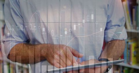 Analyzing financial data on tablet with graph overlay