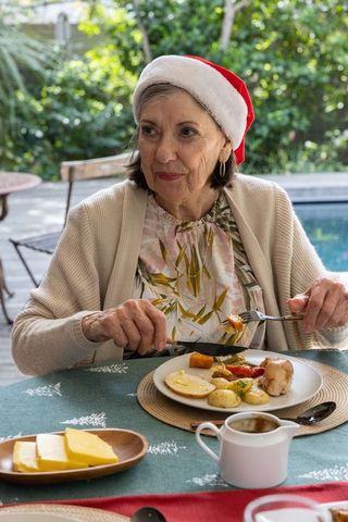 Senior Woman Enjoying Festive Holiday Meal by Poolside