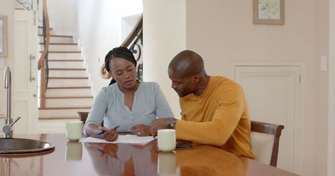 Couple Reviewing Documents, Multitasking at Home