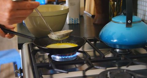 Caucasian Man Cooking Pancakes on Stove in Cozy Kitchen