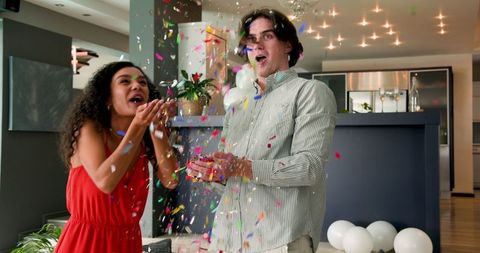 Joyful Couple Celebrating Anniversary with Confetti in Modern Living Room