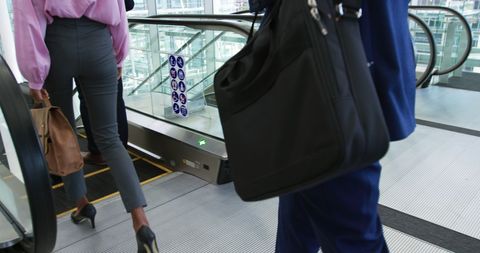 Business professionals on escalator in modern office space