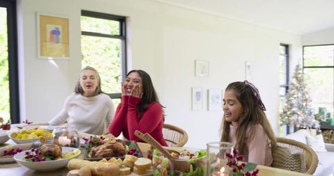 Multigenerational family celebrating holiday dinner sharing roast chicken and cozy joy
