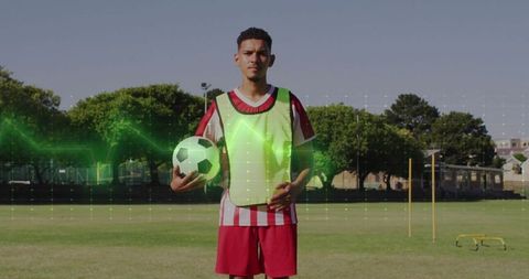 Young Soccer Player Training Outdoors with Fluorescent Vest and Ball