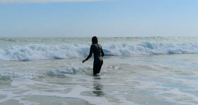 Surfer Wearing Wetsuit Facing Ocean Waves on Sunny Day - Download Free Stock Images Pikwizard.com