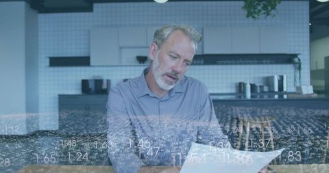 Businessman Analyzing Document in Technology-Enhanced Workspace