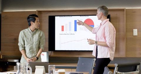 Diverse Team Analyzing Sales Charts in Modern Office