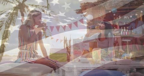 Women sipping drinks at patriotic tropical beach lounge enjoying sunset