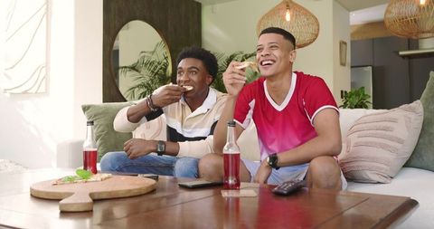 Diverse Friends Enjoying Pizza and Drinks in Cozy Living Room