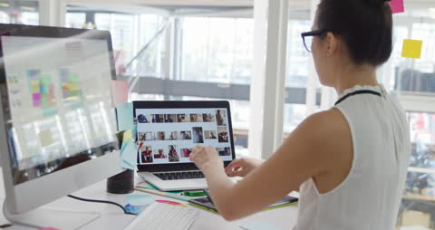 Creative Professional Working with Dual Monitors in Modern Office