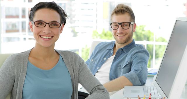 Smiling Coworkers Wearing Glasses at Office Desk - Download Free Stock Images Pikwizard.com