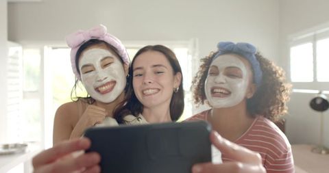 Friends taking selfie with facial masks and headbands