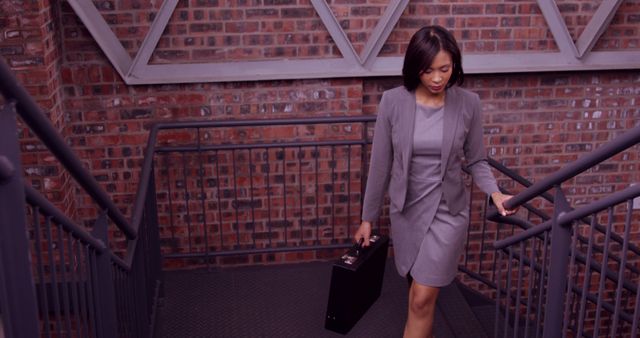 Businesswoman Walks Down Stairs Holding Briefcase - Download Free Stock Images Pikwizard.com